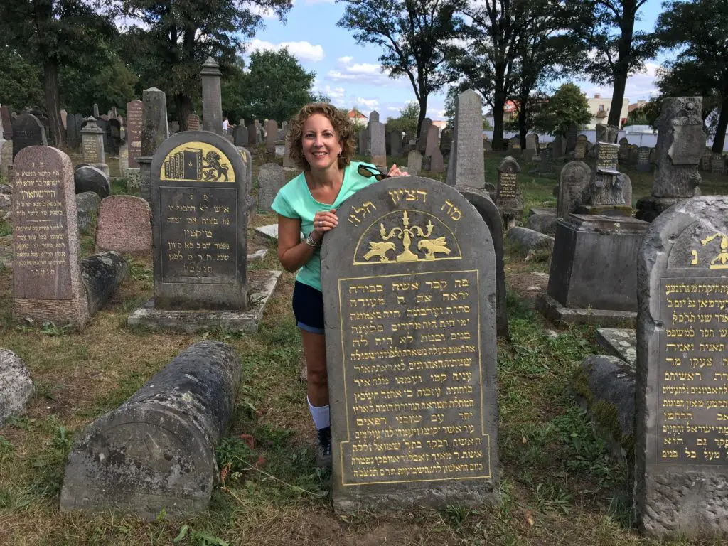 A woman standing in front of some old tombstones