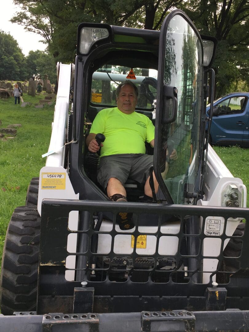 A man sitting in the back of a small tractor.