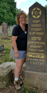 A woman standing next to a stone with writing on it.