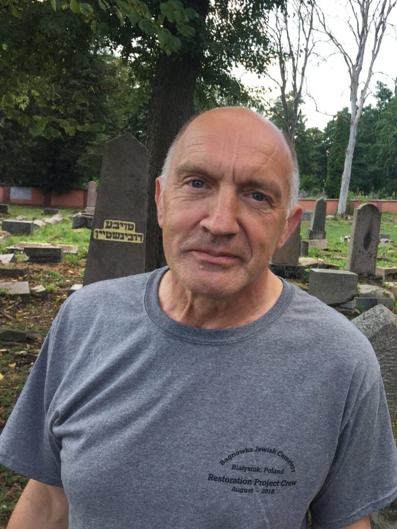 A man standing in front of some grave stones